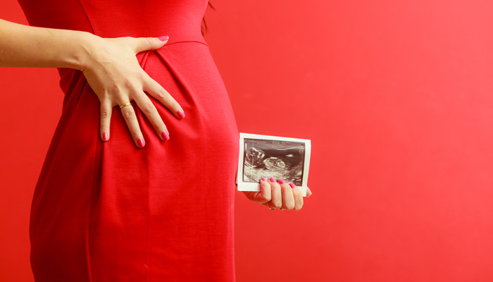摄图网_304157436_怀孕母亲和幸福穿着优雅红裙子的孕妇近身肚子室内超声波扫描（企业商用）_副本.jpg