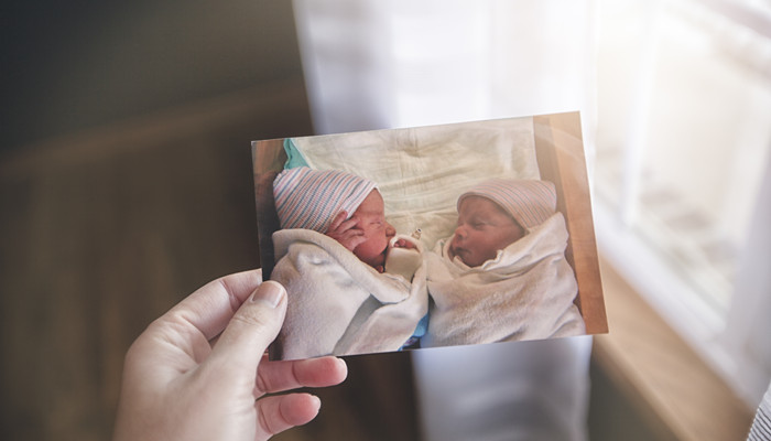 摄图网_501861732_手持双胞胎婴儿照片的母亲（企业商用）_副本.jpg